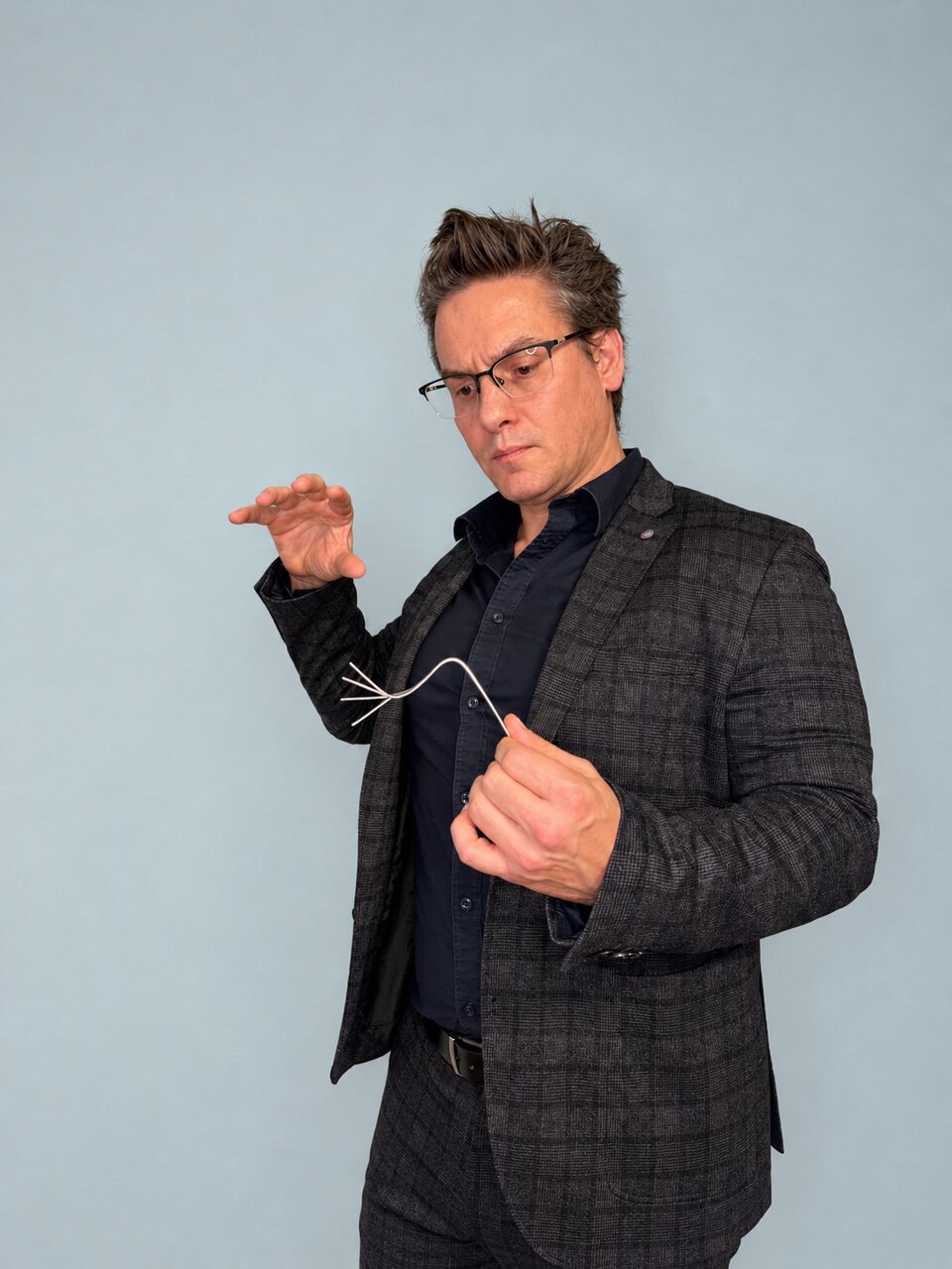 Maarten Bosmans shows a bent fork during a close-up act.